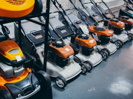 Outdoor power equipment. Home depot. Showcase of new powerful yellow gasoline lawn mower.